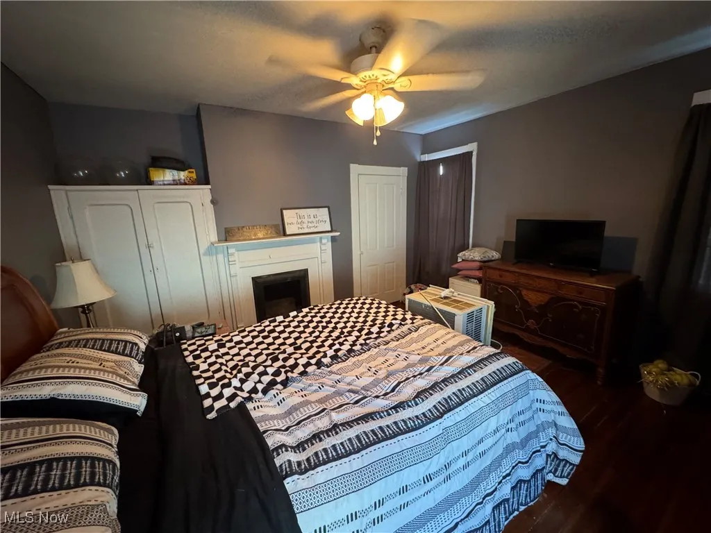 Bedroom with dark wood-style flooring and a ceiling fan