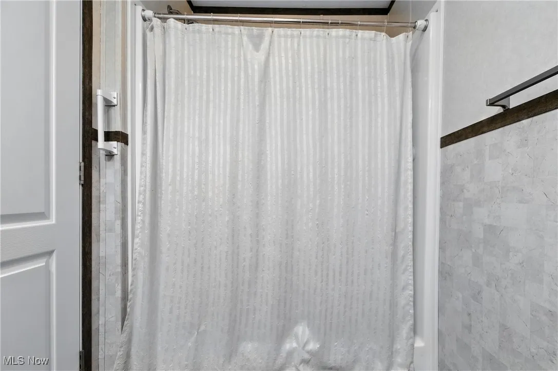 Bathroom view of a shower with curtain