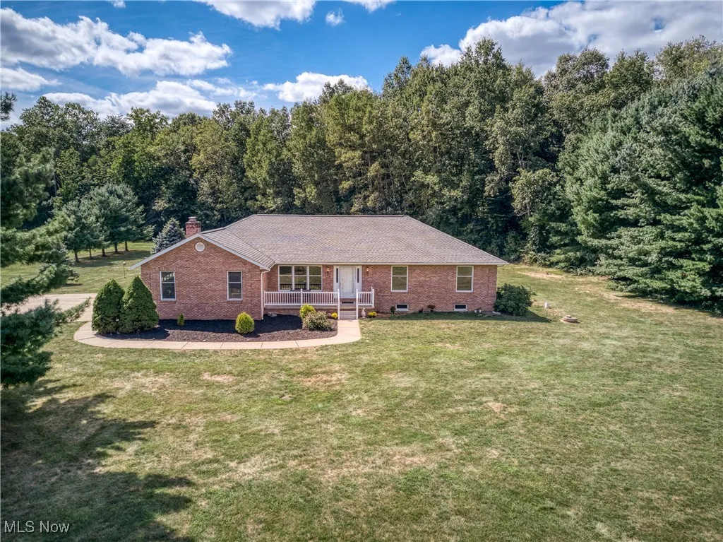 Single story home featuring brick siding, covered porch, a chimney, a front lawn, and crawl space