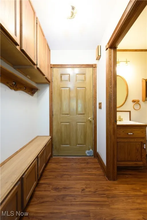 Mudroom featuring dark wood finished floors and baseboards