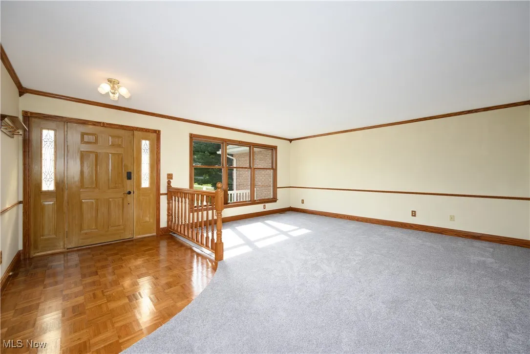 Entrance foyer with baseboards and ornamental molding