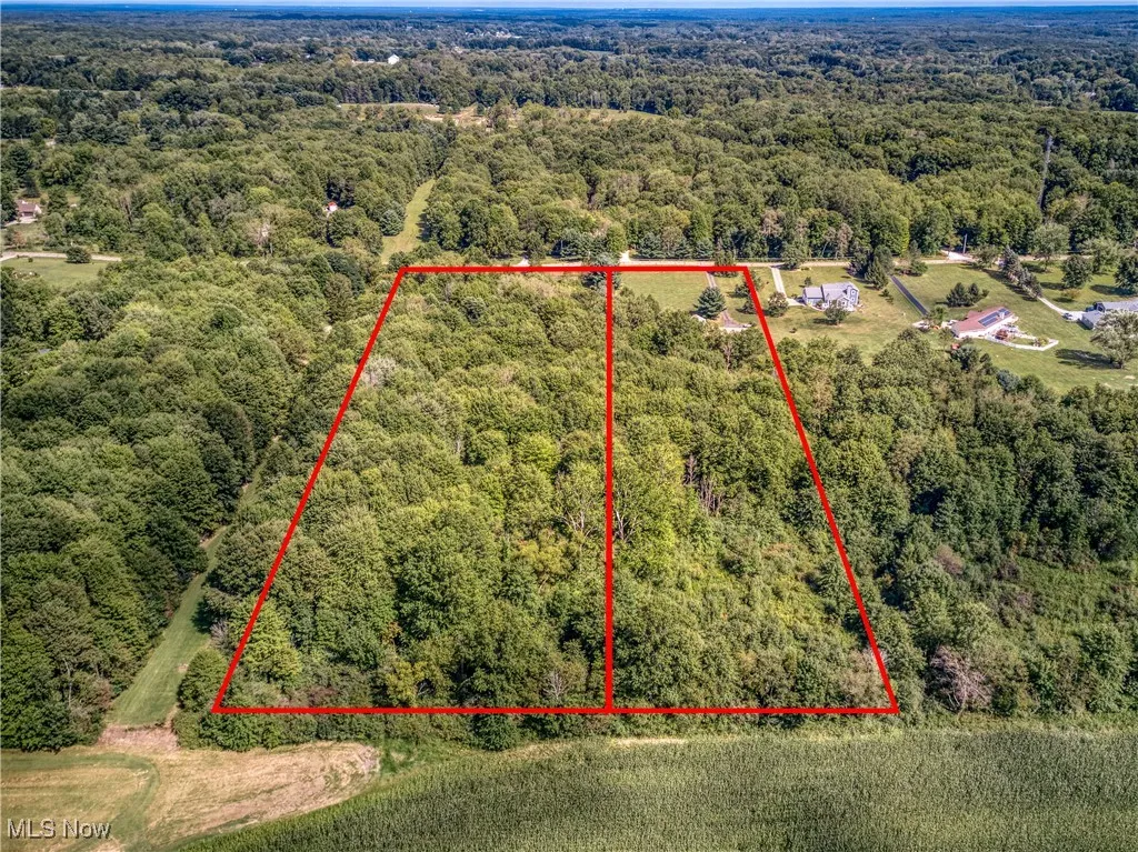 Aerial view of property's location with a heavily wooded area and property parcel outlined
