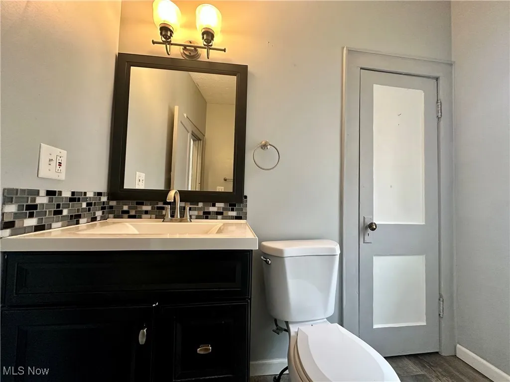 The bathroom is on the main floor and features a tasteful backsplash, vanity, walk-in shower, and laminate flooring.