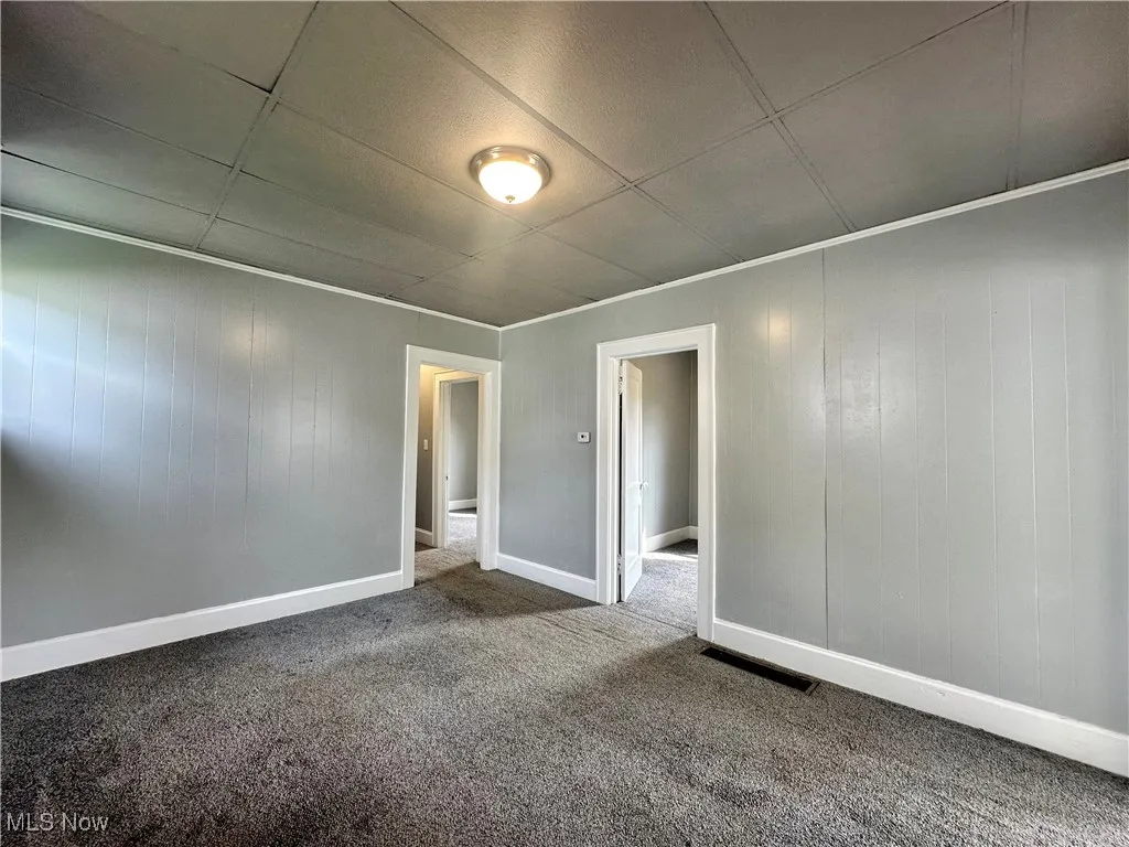Another view of the living room showing the doorways to one of the bedrooms, and the hallway with a second bedroom doorway.