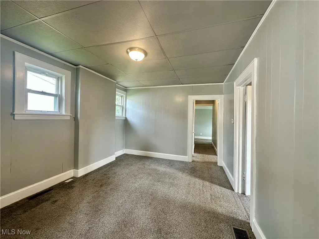 The large living room showing the hallway to the kitchen. Doorway on the right leads to a bedroom.
