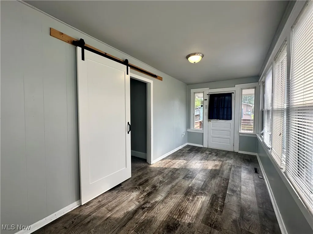 The sunroom/mudroom has a sliding barn door separating it from the living room.