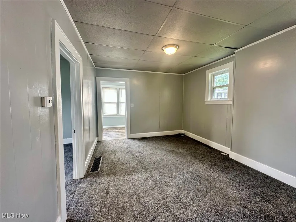 This view of the living room shows the bedroom entry to the left and the sunroom/mudroom doorway at the far end.