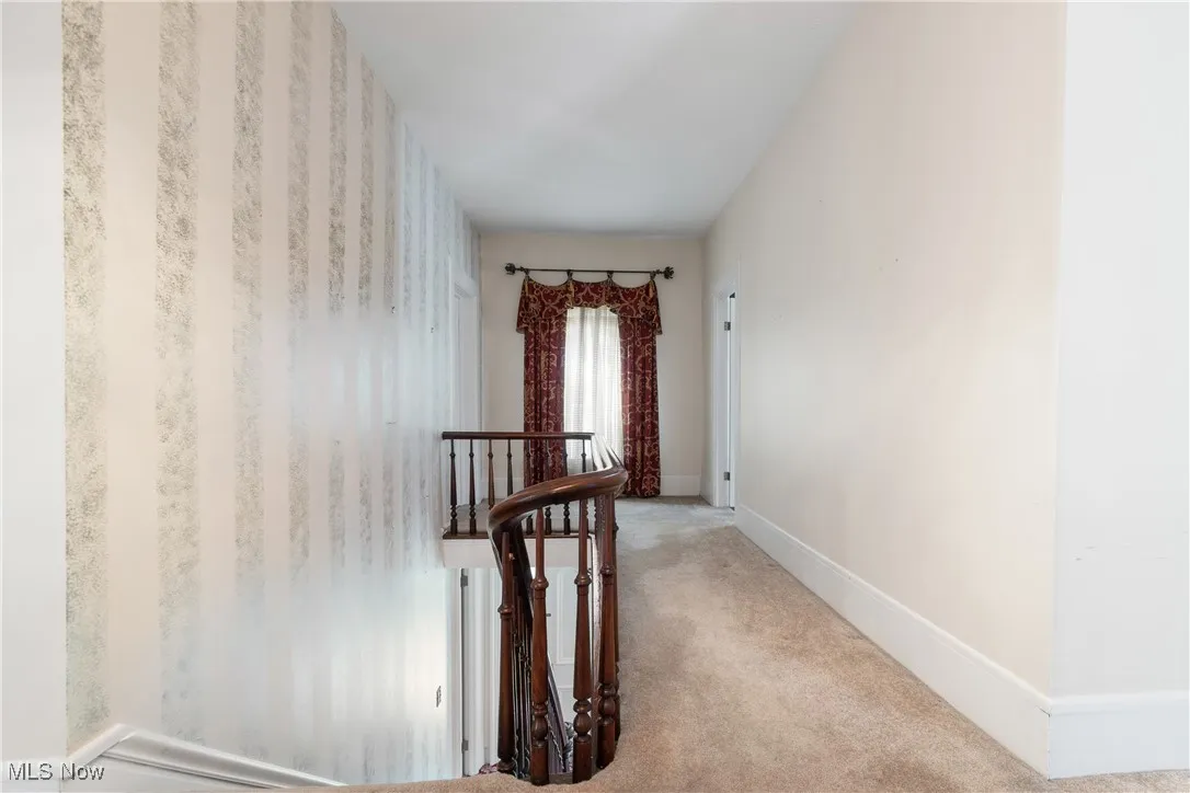 Hallway with an upstairs landing and carpet