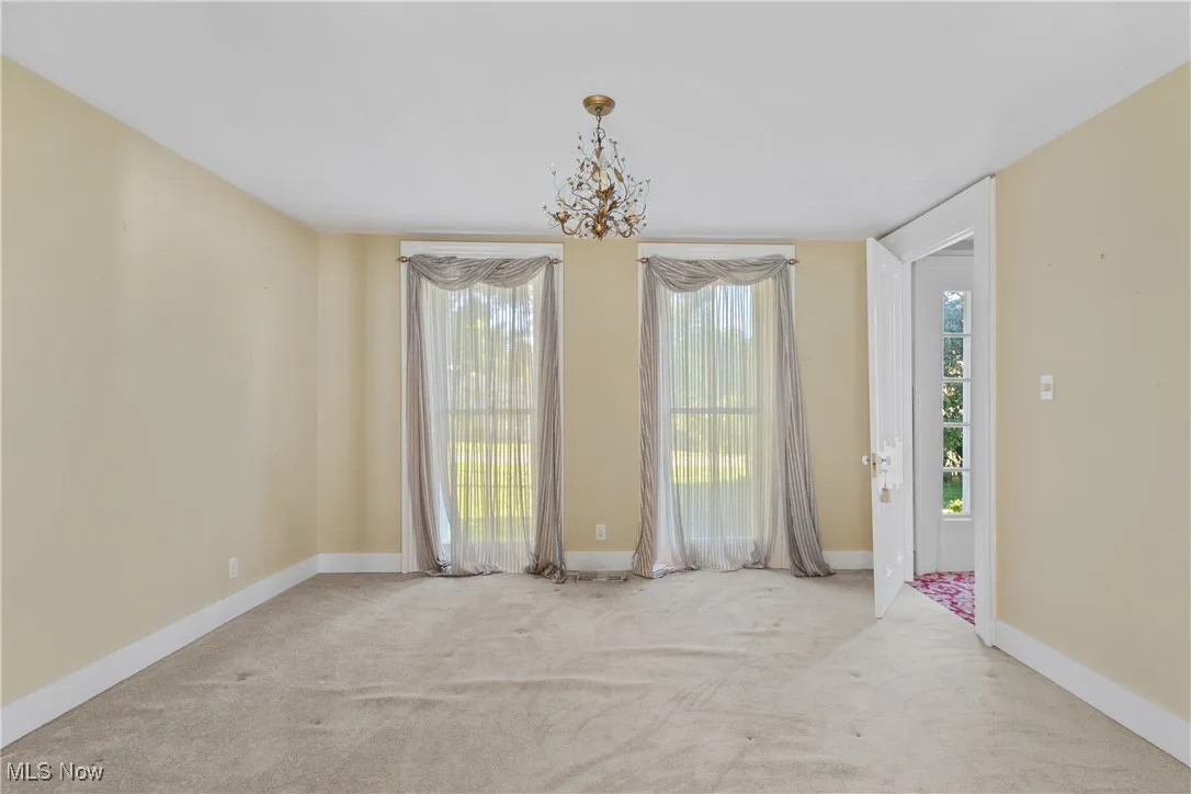 Unfurnished dining area with carpet floors and a chandelier