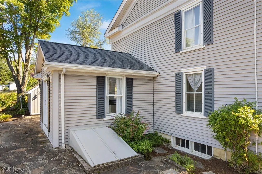 View of property exterior with roof with shingles