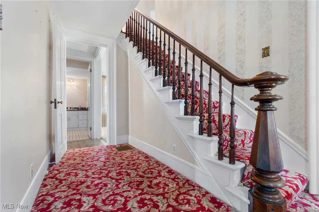 Stairs featuring baseboards and carpet