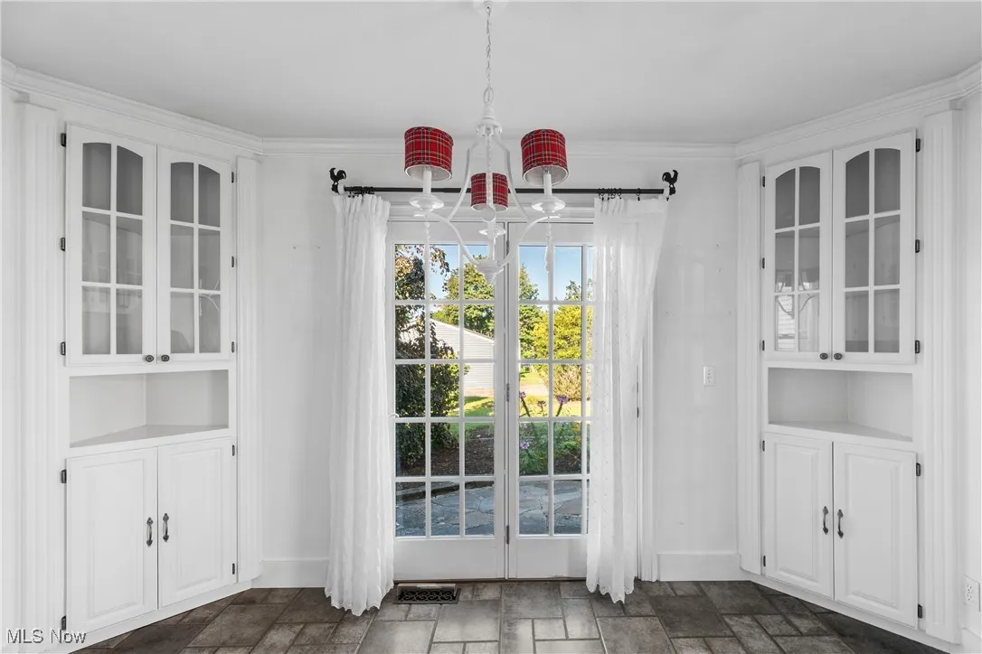 Doorway featuring stone tile flooring and ornamental molding