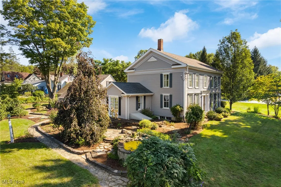 View of side of property featuring a lawn and a chimney
