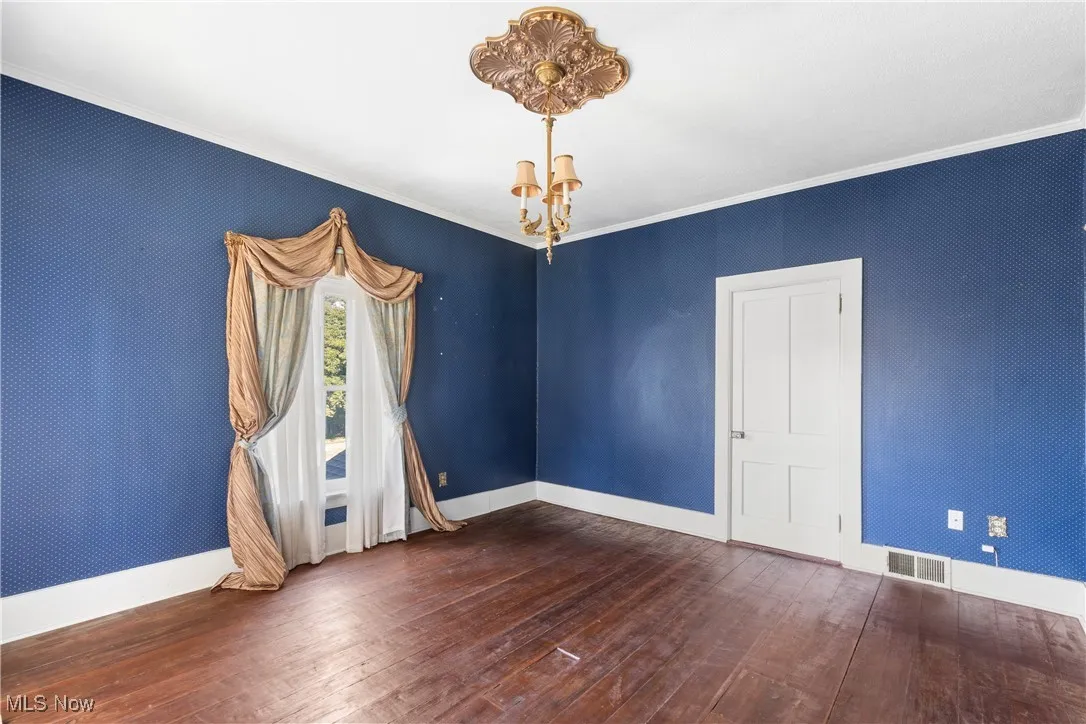Original room with crown molding, dark wood plank flooring, and a chandelier