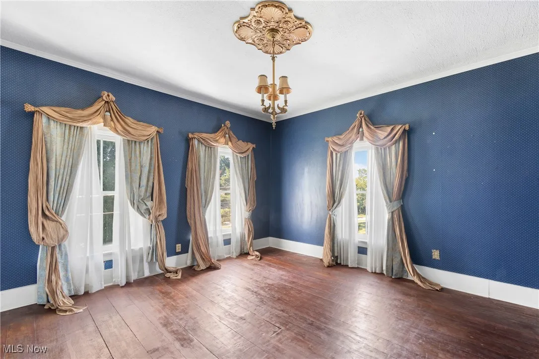 Original bedroom featuring wood plank flooring and ornamental molding