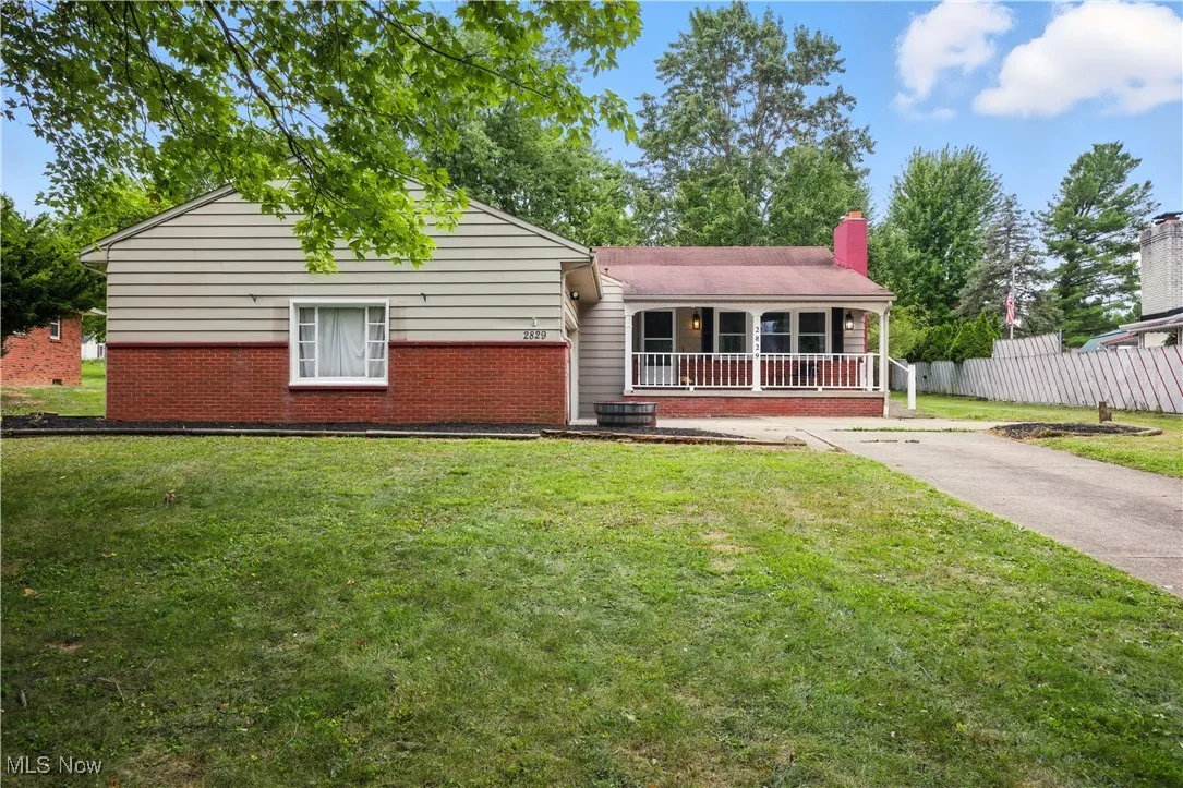 Ranch-style house with a porch, brick siding, and a chimney