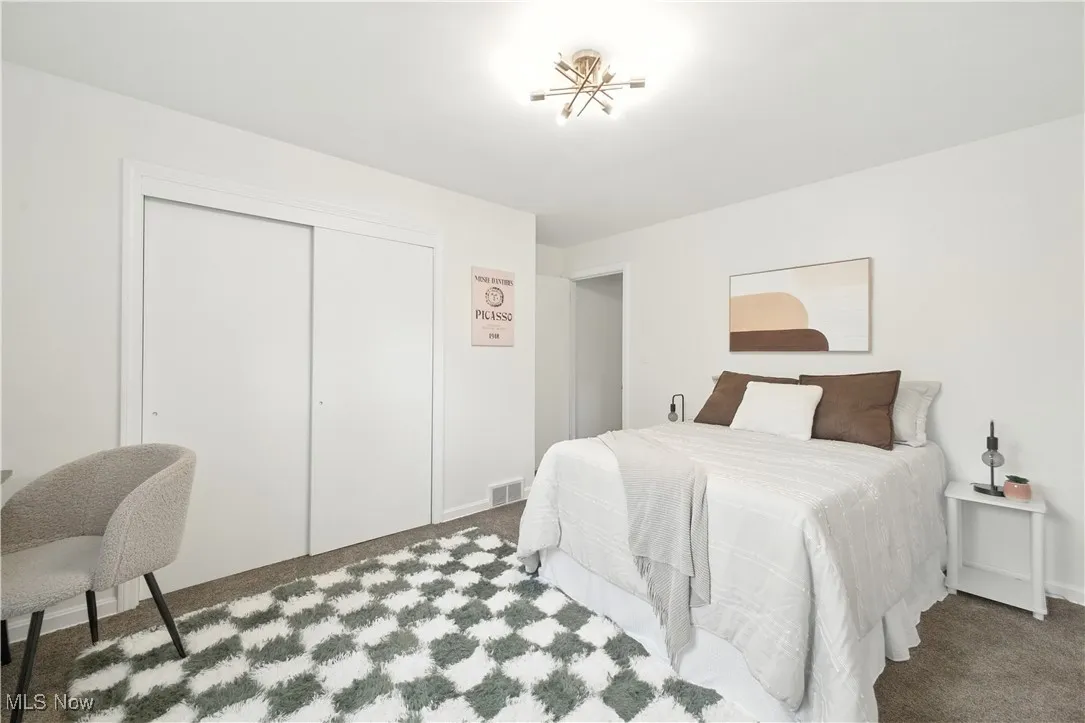 Carpeted bedroom with a closet and baseboards