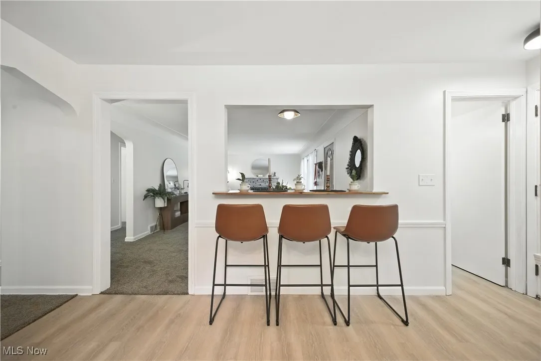 Bar featuring light wood-type flooring and baseboards