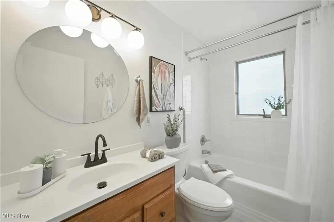Bathroom with shower / bath combo with shower curtain and vanity