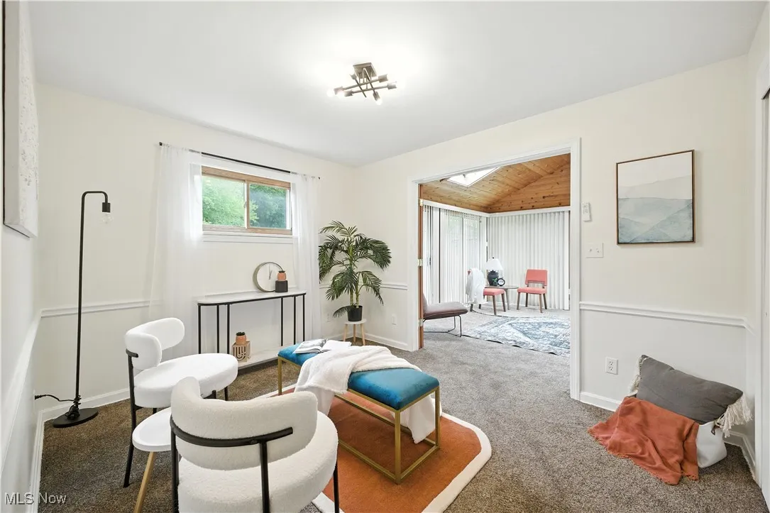 Living area featuring lofted ceiling, carpet, and wood ceiling