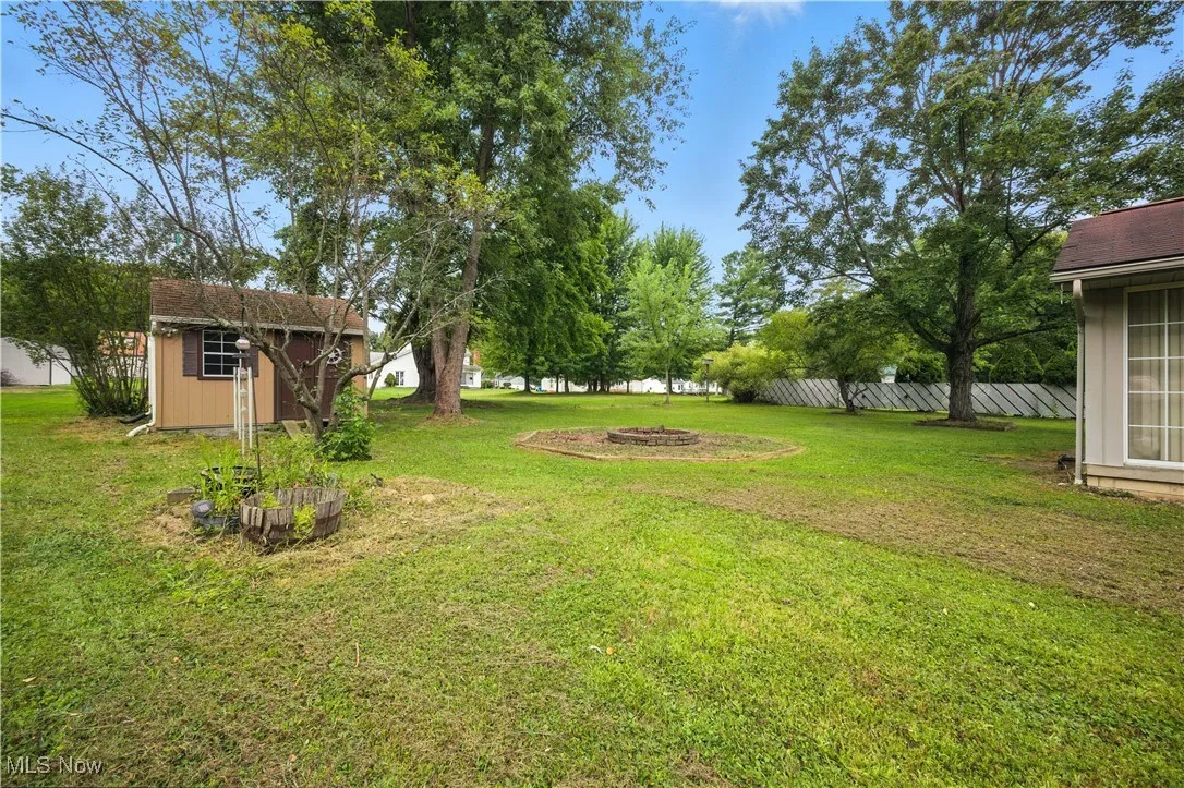 View of yard featuring a shed and an outdoor fire pit