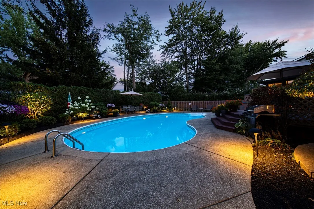 Pool at dusk featuring a patio area and a fenced backyard