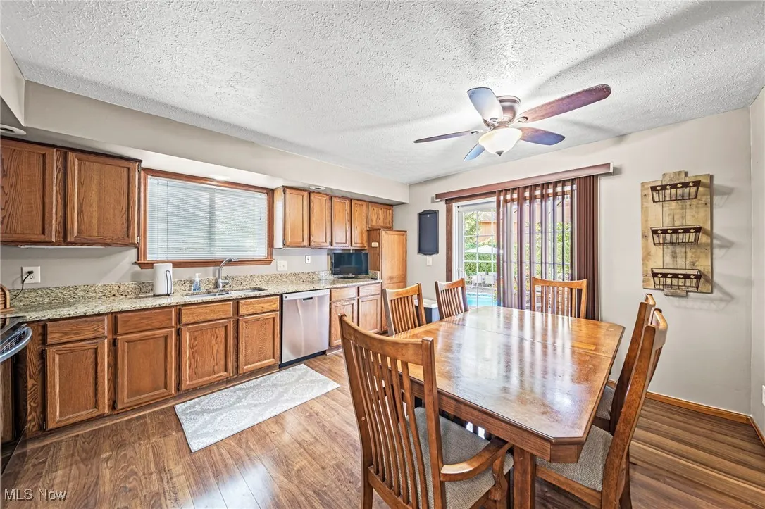 Dining room featuring dark wood-style flooring, a textured ceiling, and ceiling fan