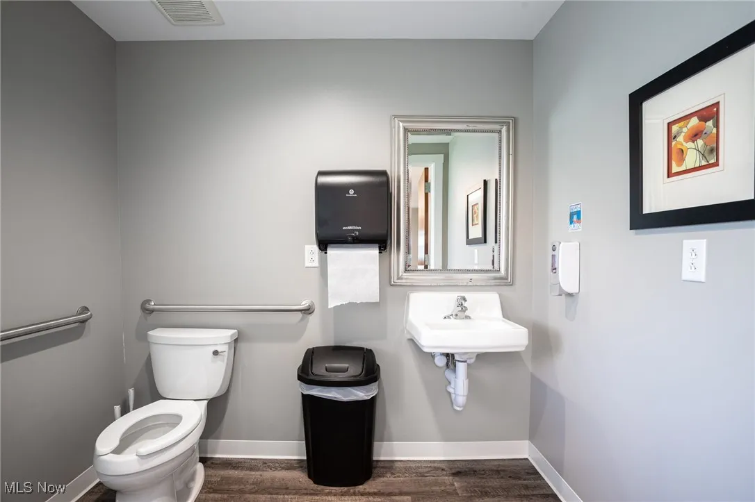 Bathroom with toilet and dark wood-style flooring