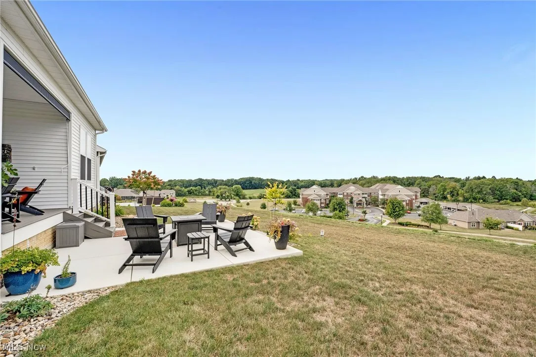 View of green lawn with a patio, a residential view, view of scattered trees, and a wooden deck