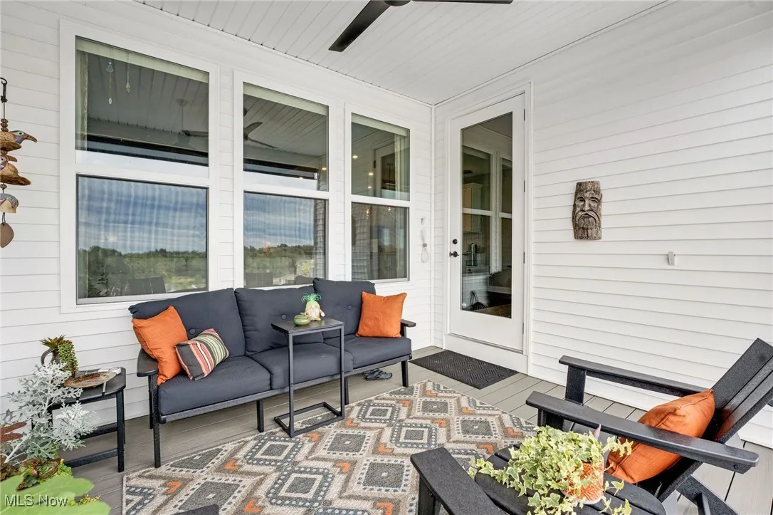View of patio featuring ceiling fan, an outdoor living space, and a wooden deck