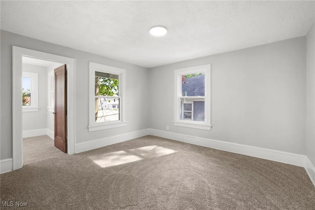 Primary bedroom featuring carpet and a sitting room area