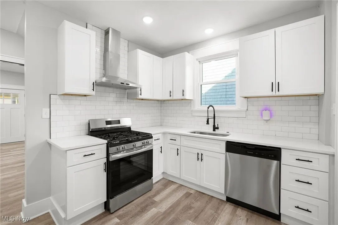 Kitchen featuring stainless steel appliances, white cabinetry, and LVT flooring