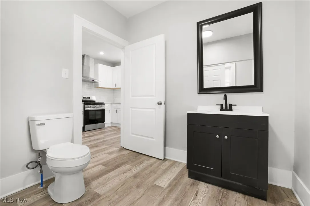 Half bath featuring vanity, LVT flooring, and toilet