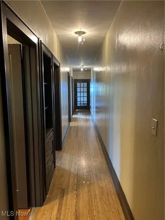 Hallway featuring light wood-type flooring and baseboards