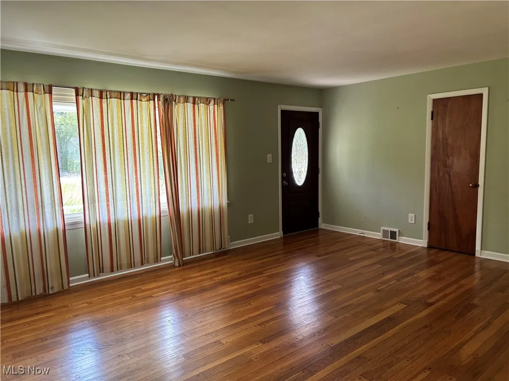 Foyer with healthy amount of natural light and dark wood-style flooring
