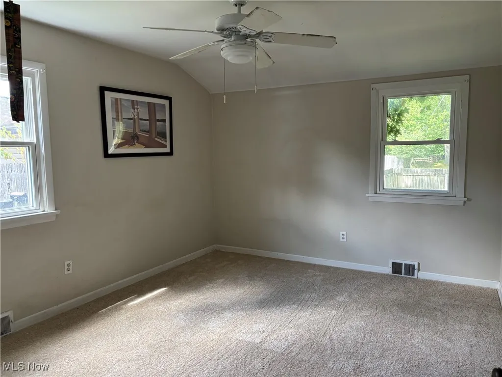 Unfurnished room with carpet flooring, ceiling fan, and lofted ceiling