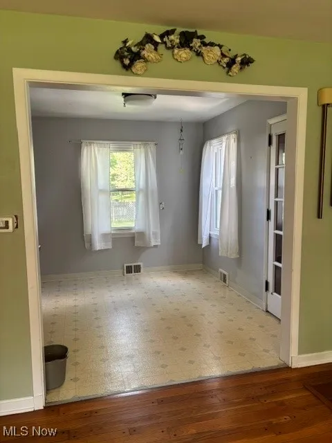 Spare room featuring wood-type flooring and baseboards