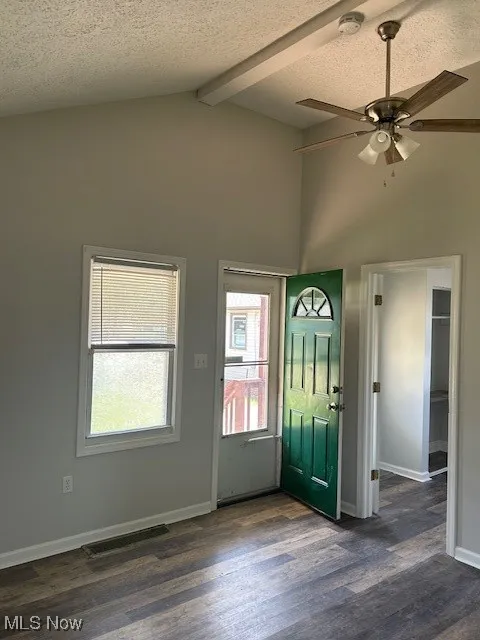 Foyer featuring a textured ceiling, dark wood-style floors, and ceiling fan