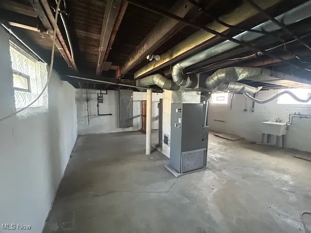 Basement featuring heating unit and a sink