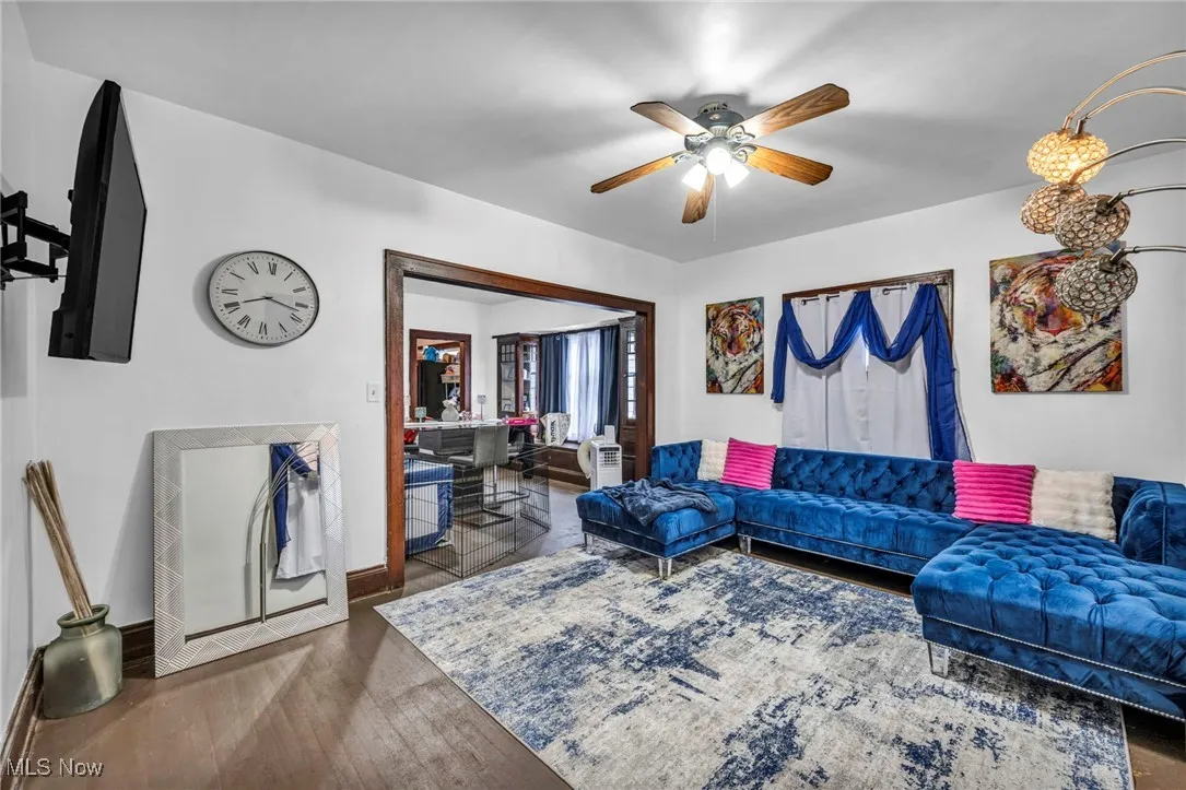Living area with dark wood-style floors and ceiling fan