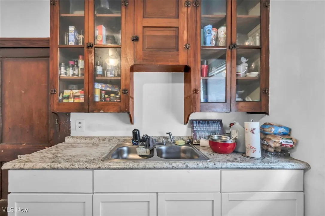 Kitchen featuring glass insert cabinets and light countertops