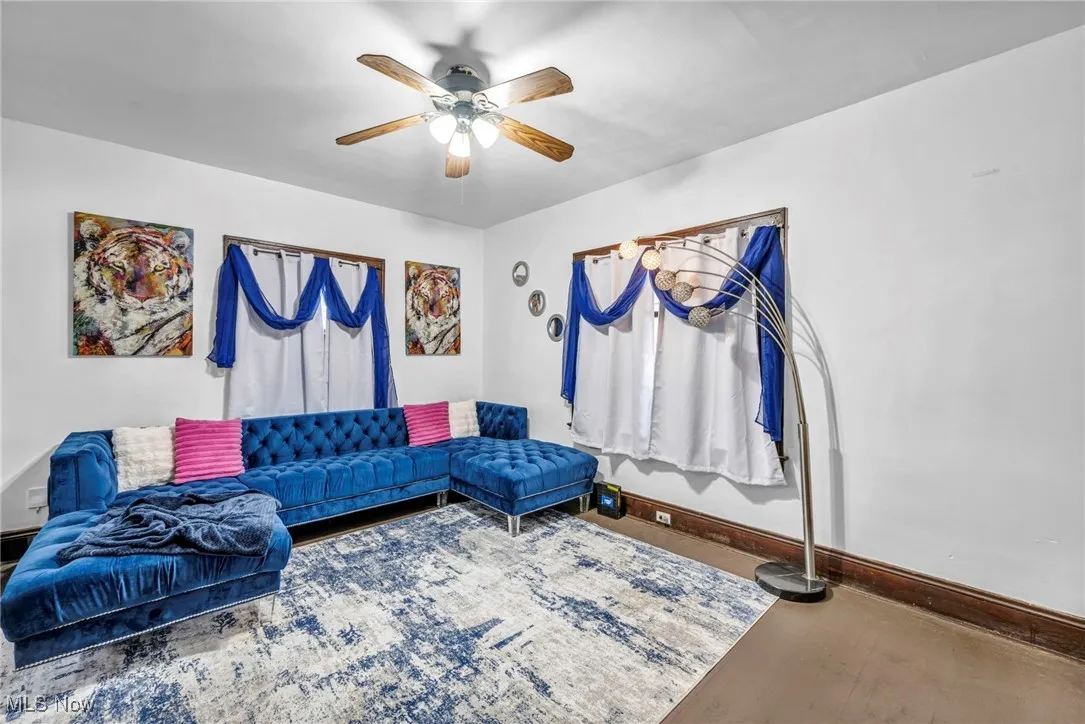 Living room with a ceiling fan and baseboards