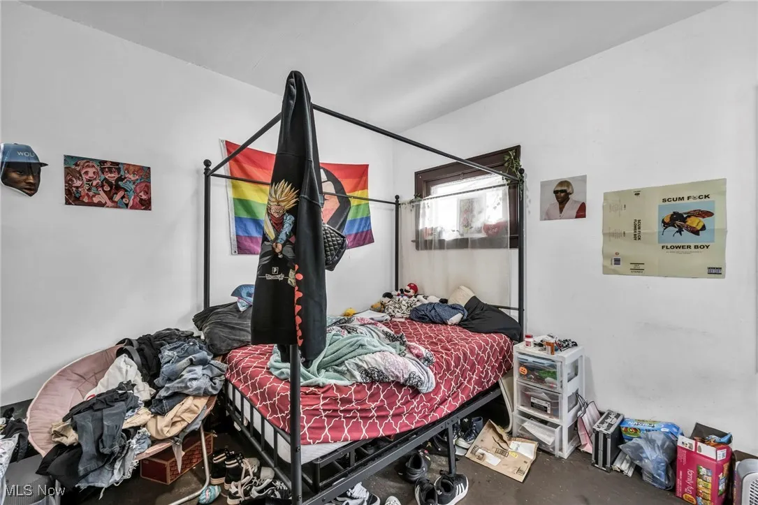 Bedroom with unfinished concrete floors