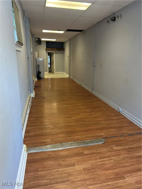 Unfurnished room with light wood finished floors and a paneled ceiling