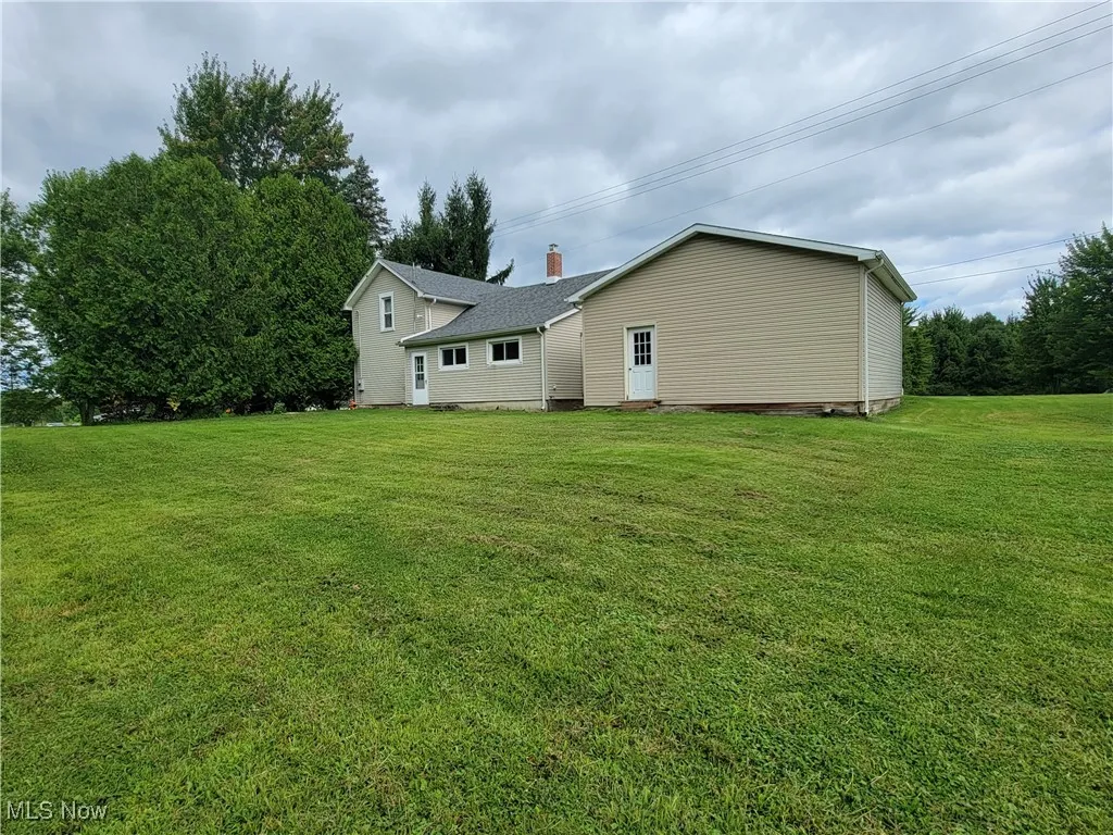 Back of property featuring a yard and a chimney