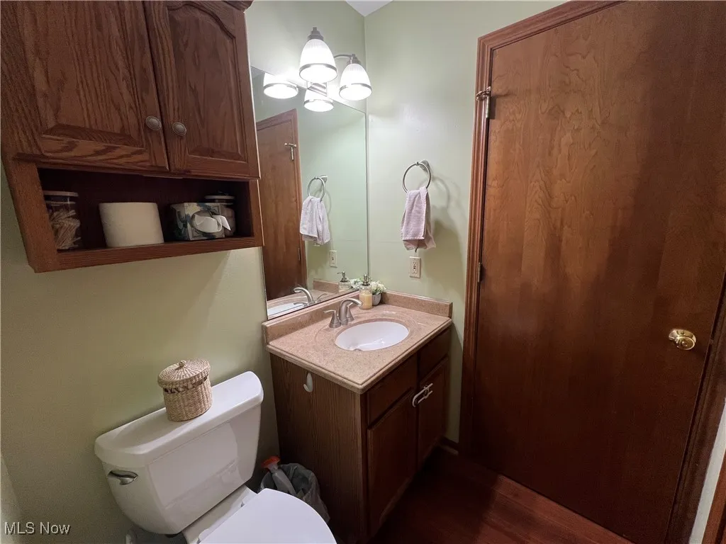 1st-floor Half-Bath featuring vanity, laminate flooring