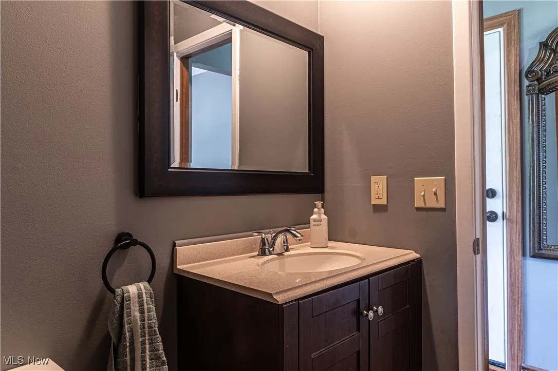 Half bathroom with a textured wall and vanity