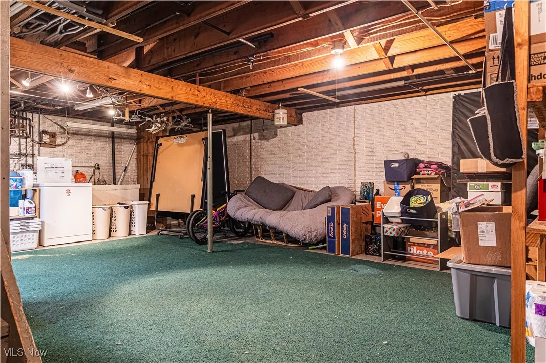 Unfinished basement featuring washer / dryer and carpet floors