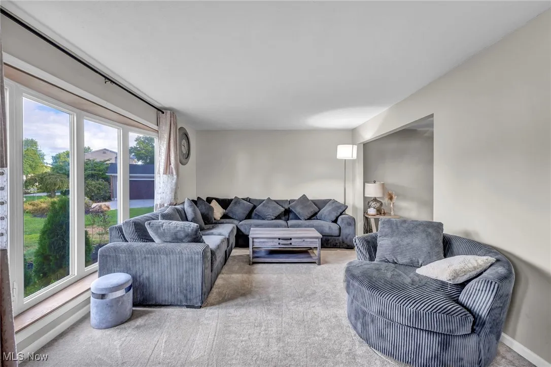 Carpeted living room featuring baseboards
