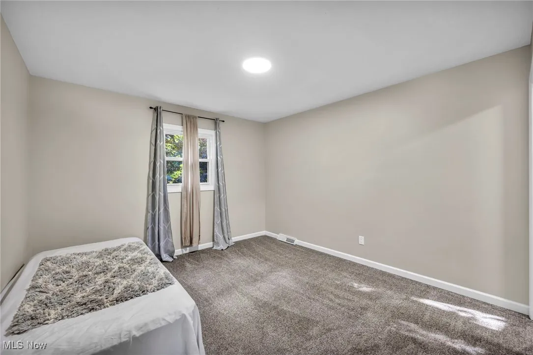 Unfurnished bedroom with carpet flooring and baseboards